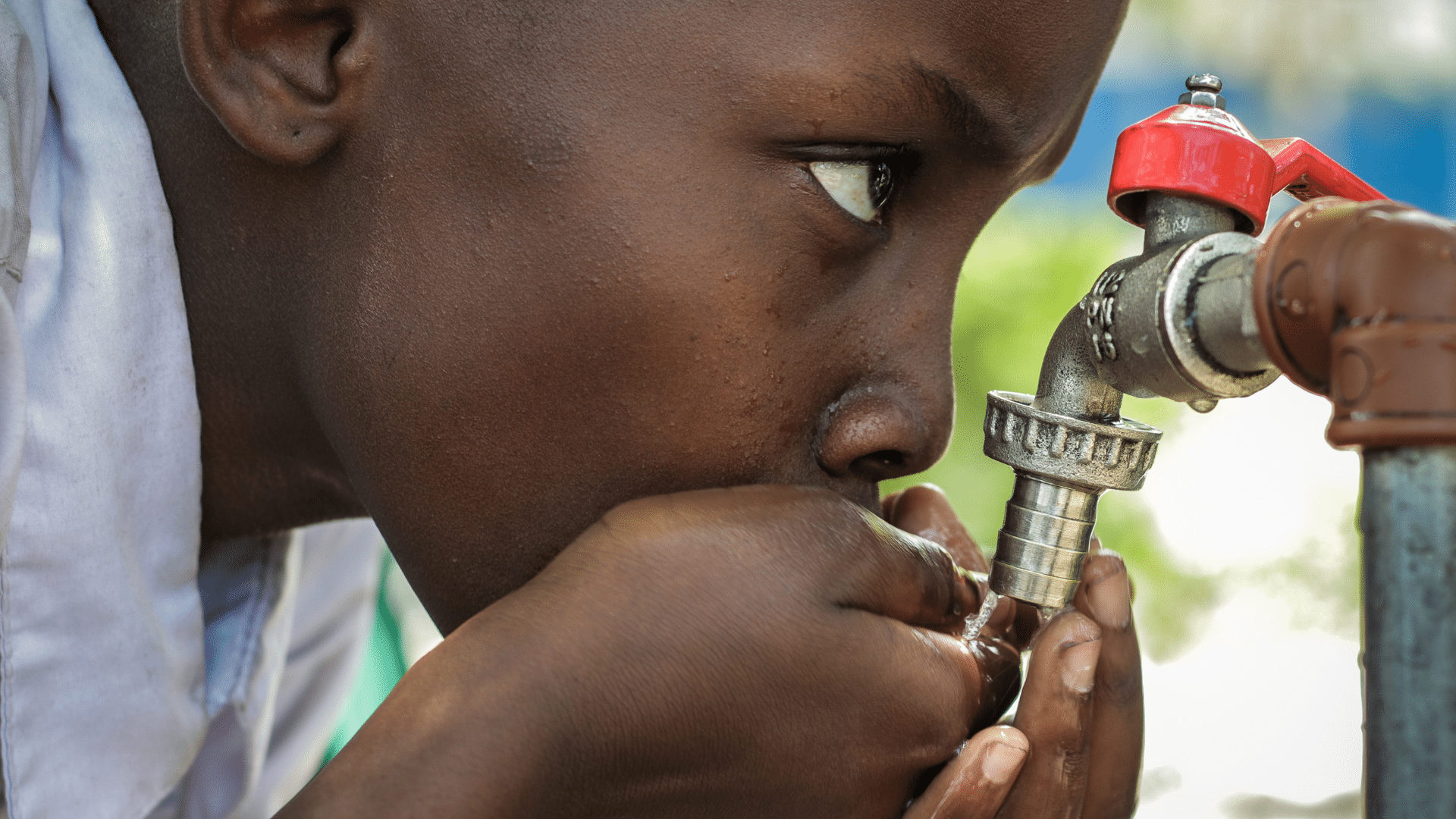 Enfant qui boit de l'eau alors que la ressource est en perdition causant des guerres pour l'eau